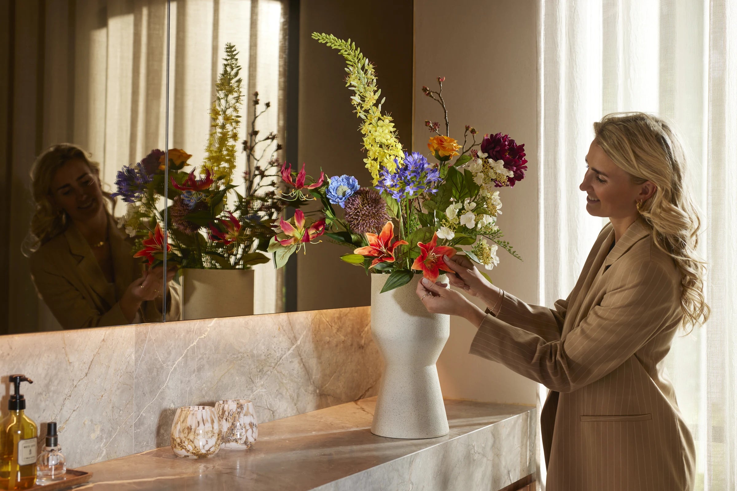 Blomster blir arrangert for hånd i en vase